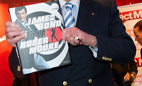 Rogeris Moore'as Paryžiuje pristatė savo knygą apie Džeimsą Bondą