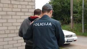 Policininkas veda sulaikytąjį