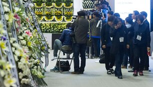 Gedintieji prie memorialo Pietų Korėjoje nuskendusio kelto Sewol aukoms