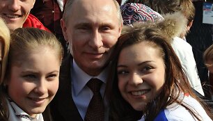 Russia's President Vladimir Putin (C) poses for a photo with figure skaters Adelina Sotnikova (R) and Julia Lipnitskaya (L) after an awarding ceremony for Russian athletes, winners of the Sochi 2014 Winter Olympics, in Sochi, on February 24, 2014. AFP PHOTO/ RIA-NOVOSTI/ POOL / MIKHAIL KLIMENTYEV