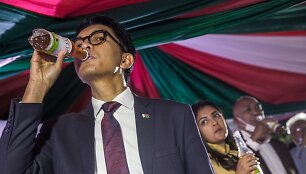 Madagaskaro prezidentas Andry's Rajoelina žurnalistams demonstruoja geriantis tariamą vaistą nuo COVID-19 &bdquo;Covid Organics&ldquo; 