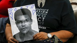 Moteris laiko Muhammado Ali portretą