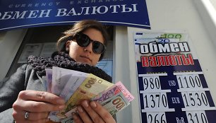 Moteris laiko Ukrainos nacionalinės valiutos grivinos banknotus