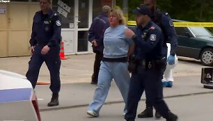 Įvykio vietoje policijos pareigūnai veda sulaikytą moterį.