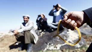Turkijos kardai prie sienos stebi mū&scaron;ius Kobanėje, o &scaron;alia esanti moteris meldžiasi