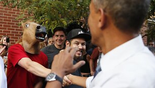 JAV prezidentas Barackas Obama sveikinasi su vyru, dėvinčiu arklio galvos kaukę.