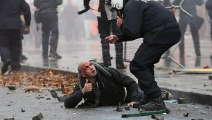 Belgijos policininkas ir sužeistas protestuotojas 