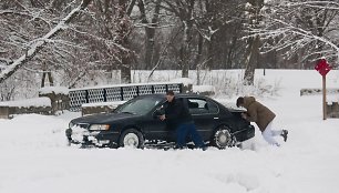 Stumiamas sniege užklimpęs automobilis