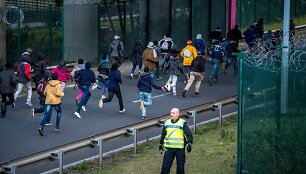 Migrantai bėgantys link Eurotunelio Prancūzijoje nekreipia dėmesio į policininką