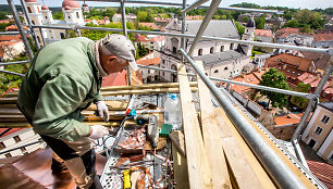 Aukštybėse dirbantys statybininkai tvarko unitų bažnyčios bokštą