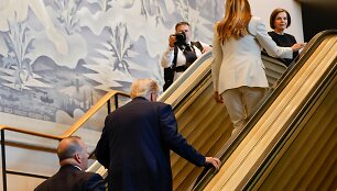 Donaldas Trumpas ir Melania Trump užlipa eskalatoriumi, kuris netikėtai sustojo / AP
