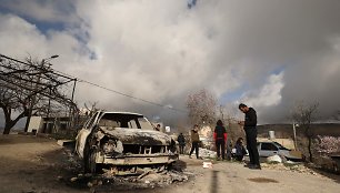 Palestiniečiai apžiūri apdegusį automobilį po to, kai jį, kaip įtariama, padegė izraeliečiai