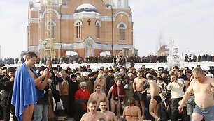 Žmonės brenda į vandenį.