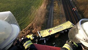 Ugniagesys žiūri į sudužusį vilkiką, kuris nukrito i&scaron; 10 metrų auk&scaron;čio tilto ant traukinio bėgių tarp Berlyno ir &Scaron;tralzundo. 