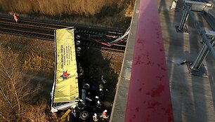 Ugniagesys žiūri į sudužusį vilkiką, kuris nukrito i&scaron; 10 metrų auk&scaron;čio tilto ant traukinio bėgių tarp Berlyno ir &Scaron;tralzundo. 