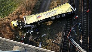 Ugniagesiai žiūri į sudužusį vilkiką, kuris nukrito i&scaron; 10 metrų auk&scaron;čio tilto ant traukinio bėgių tarp Berlyno ir &Scaron;tralzundo. 