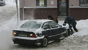 Kauniečiai stumia mašiną.