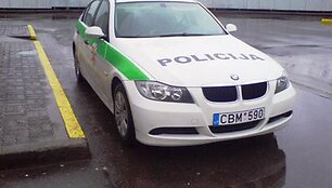 Policijos automobilis prie geltonos linijos