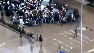 Laidotuvių procesijos dalyviai puola slėptis nuo kulkų.