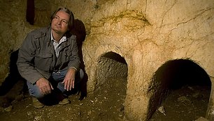 Archeologas Shimonas Gibsonas prie laidojimo nišos