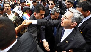 Alvaro Uribe (de&scaron;inėje) yra nepaprastai populiarus savo &scaron;alyje, tačiau nebegalės dar karą būti renkamas prezidentu.