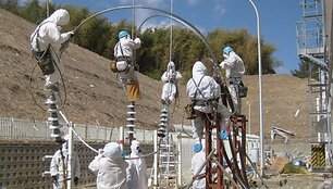 Darbininkai Fuku&scaron;imos-1 atominėje elektrinėje mėgina atkurti elektros energijos tiekimą į reaktorių įrenginius.