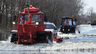 Automobiliai per apsemtą kelio atkarpą keliami specialia technika.