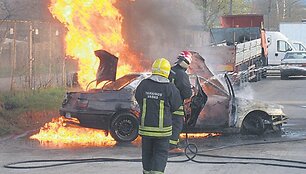 Ugniagesiai gesina automobilį.