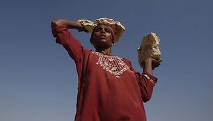 Noor Jan, per potvynius Pakistane likusi be pastogės, ne&scaron;a akmenis, kad sutvirtintų savo palapinę, kurioje ji glaudžiasi.