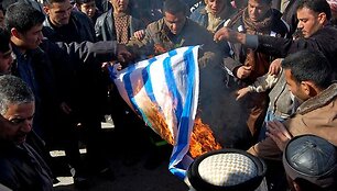 Irake vykusiame proteste prie&scaron; Gazos ruožo bombardavimą deginta Izraelio vėliava.