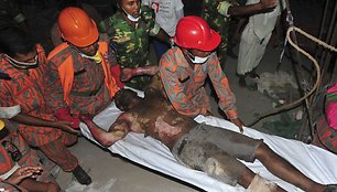 Bangladeše gelbėtojai iš po griuvėsių traukia siuvimo fabriko darbuotojus.