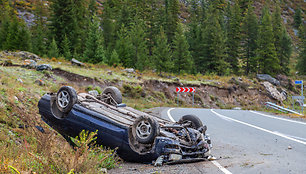 Car accident place on a bend, overturned car lies on the roof,