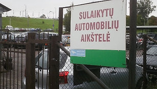 Sulaikytas automobilis stovi iš karto už tvoros