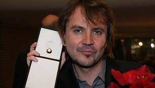 Oskaras Kor&scaron;unovas matuojasi gautą Boriso Dauguviečio premiją-auskarą