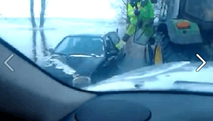 Vairuotojos, pamir&scaron;usios užtraukti rankinį stabdį, automobilis nuriedėjo nuo tralo, keliančio transporto priemones per potvynio užlietą kelą.