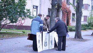 Piketuotojai atsine&scaron;ė plakatus. 