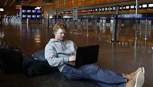 Žmogus dirba su kompiuteriu oro uoste