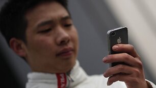 Žmogus naudojasi telefonu &bdquo;iPhone&ldquo;