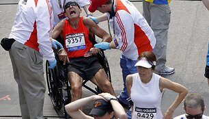 Medikai į vežimėlį sodina sunegalavusį Bostono maratono dalyvį.