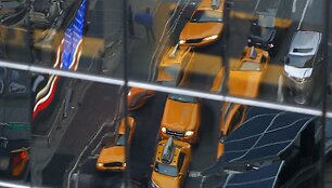 Taksi automobiliai atsispindi Niujorko pastato lange