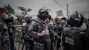Katmandu policija prižiūri autobusų laukiančias minias žmonių.
