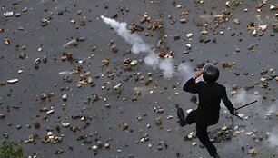 Policininkas nuspiria protestuotų atmestą a&scaron;arinių dujų balionėlį