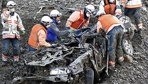 Gelbėtojai prie sulamdyto automobilio.
