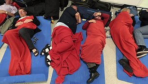 Prie savo lagaminų miegantys keliautojai Edinburgo oro uoste
