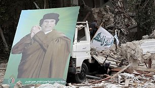 Muamaro Kadhafi plakatas prie sugriuvusio pastato Tripolyje