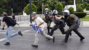Policininkai vaiko protestuotojus Atėnuose.