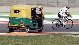 Jarno Trulli (dešinėje) važiuoja pro Jensono Buttono vairuojamą rikšą