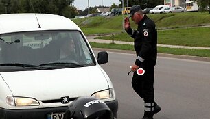 Policijos pareigūnas stabdo transporto priemonę