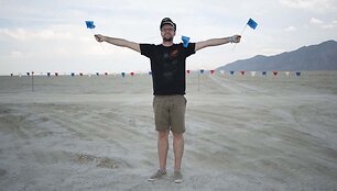 Pirmąkart į &bdquo;Burning Man&ldquo; atkeliavęs Vytautas pozuoja su stovyklos ribas žyminčiomis vėliavėlėmis