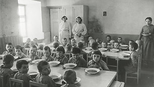 Priešmokyklinio amžiaus karo atbėgėlių vaikučiai prie stalo pietų metu. Įdomu, kas tose mažose jų galvutėse, tur būti dar prisimenančiose, kad vos prieš keletą mėnesių jie pietaudavo savo tėvų namuose, o dabar tenka nuo šeimų atskirtiems, dažnai ir tėvę netekus, glaustis ir misti tarp nepažįstamų žm